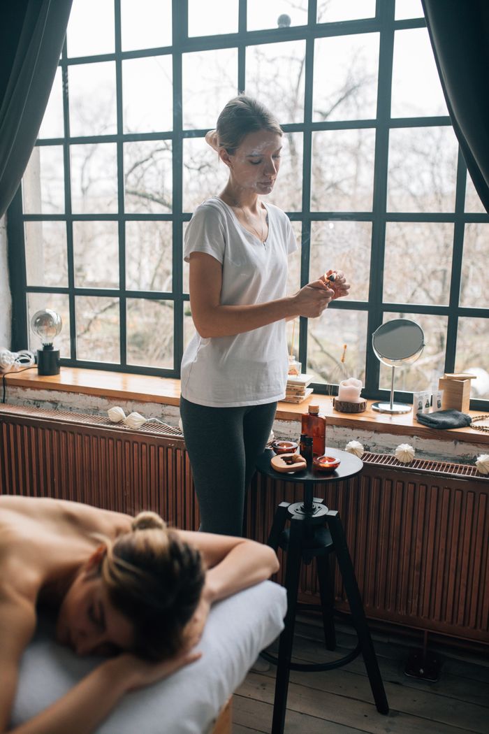 Massage therapist applying oils during a relaxing spa treatment in a serene setting.