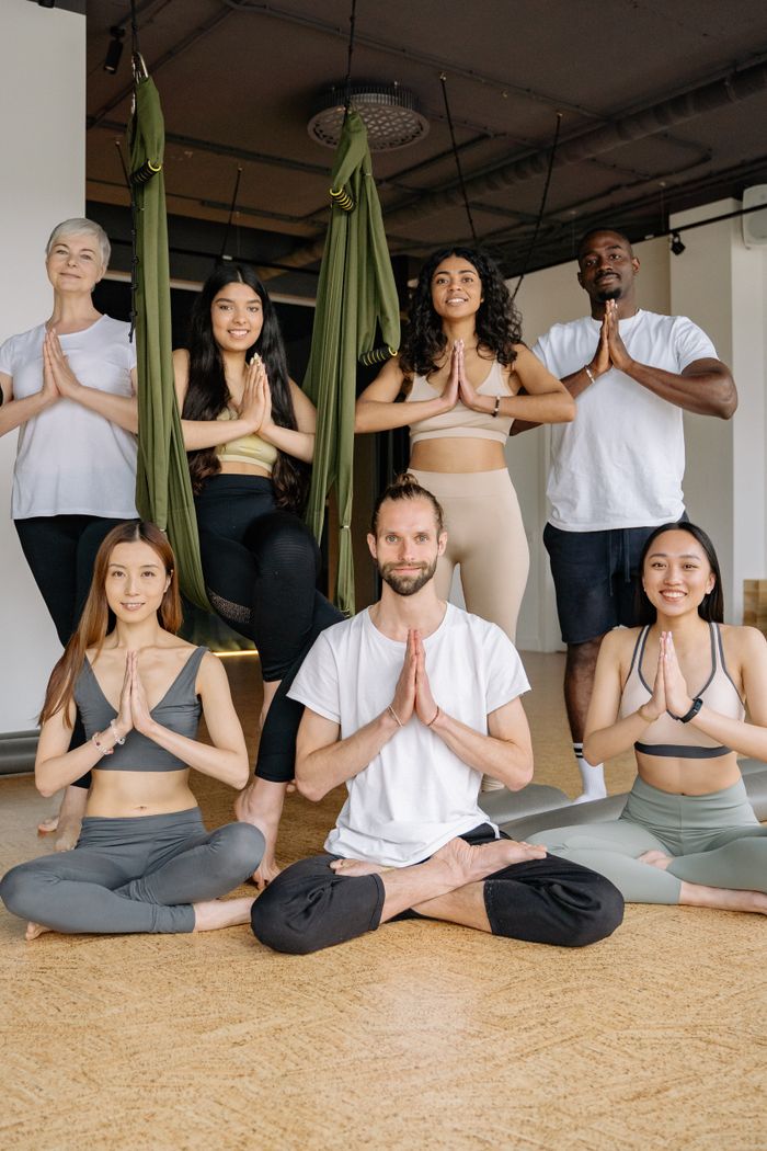 A multicultural group practicing yoga poses in an indoor studio setting, embracing health and mindfulness.
